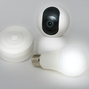 A set of smart home devices including a camera, speaker, and lightbulb on a white background.