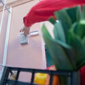 Close-up of a person using a security keypad on a gate, highlighting home access control.