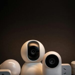 Close-up of modern white security cameras and smart home devices with dark background.